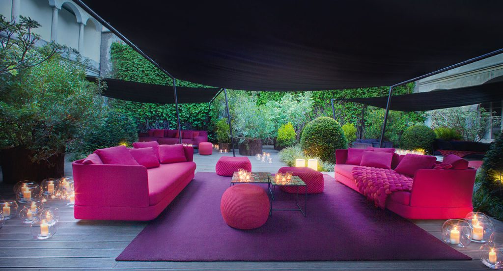Two Berry poufs made of pink woven upholstery in a terrace.