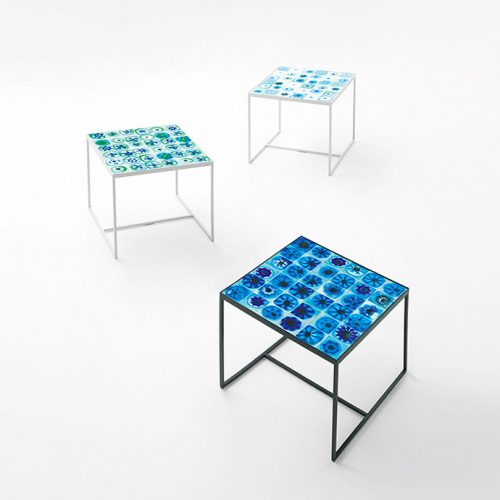Three Bloom side tables, structure and legs in black steel, top decor in blue and white glass with irregular patterns on a a white background.