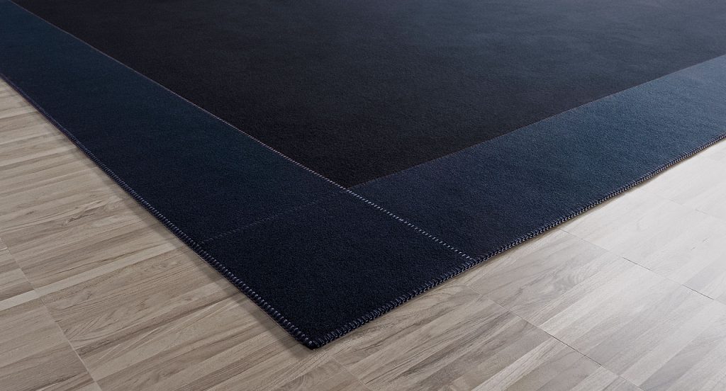 Rectangle Cornice 25 rug made of blue felt on a brown floor.