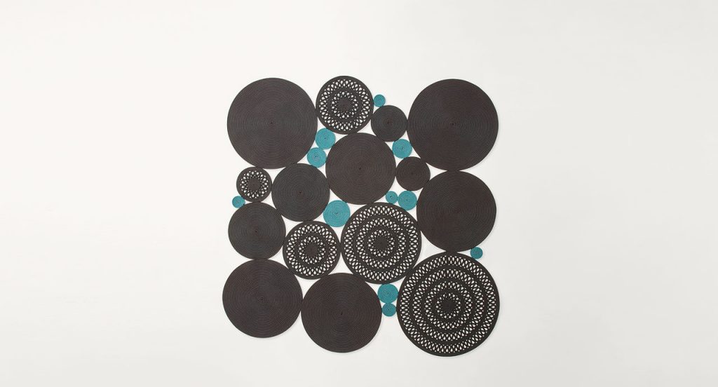 Cosmo rug, made of blue and brown round modules on a white background.