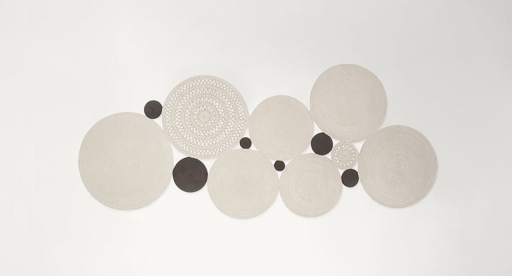 Cosmo rug, made of white and brown round modules on a white background.