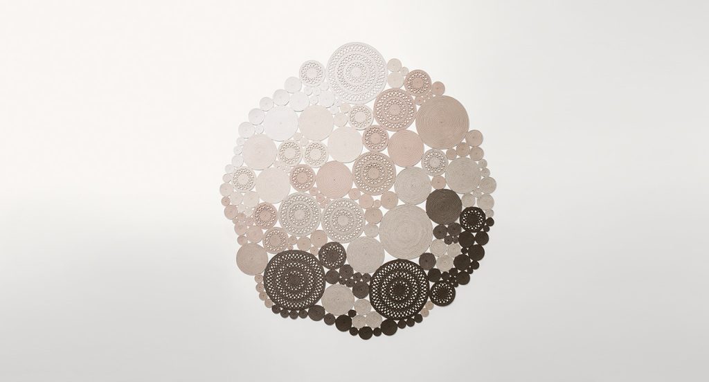 Cosmo rug, made of white, beige and brown round modules on a white background.