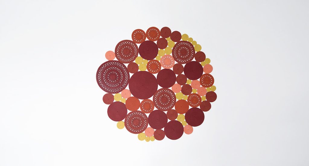 Cosmo rug, made of yellow, orange and brown round modules on a white background.