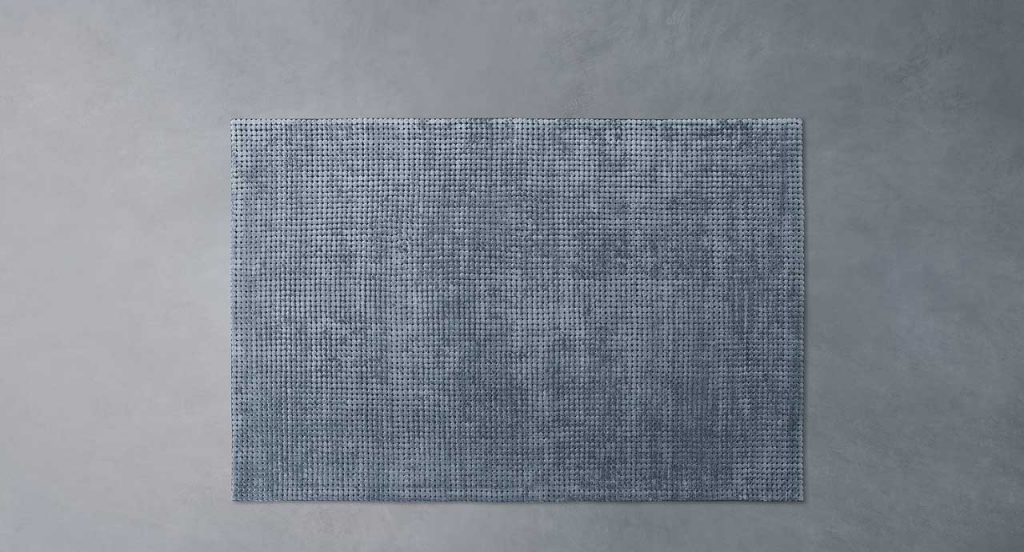 Crown rug made of grey wool on a grey background.