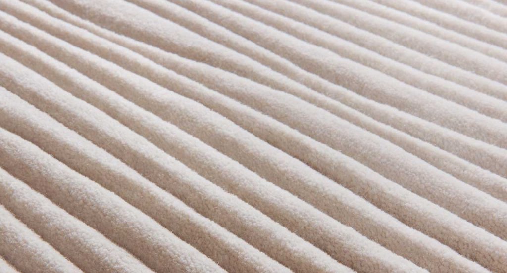 Deep rug made of white irregular curved lines pattern.