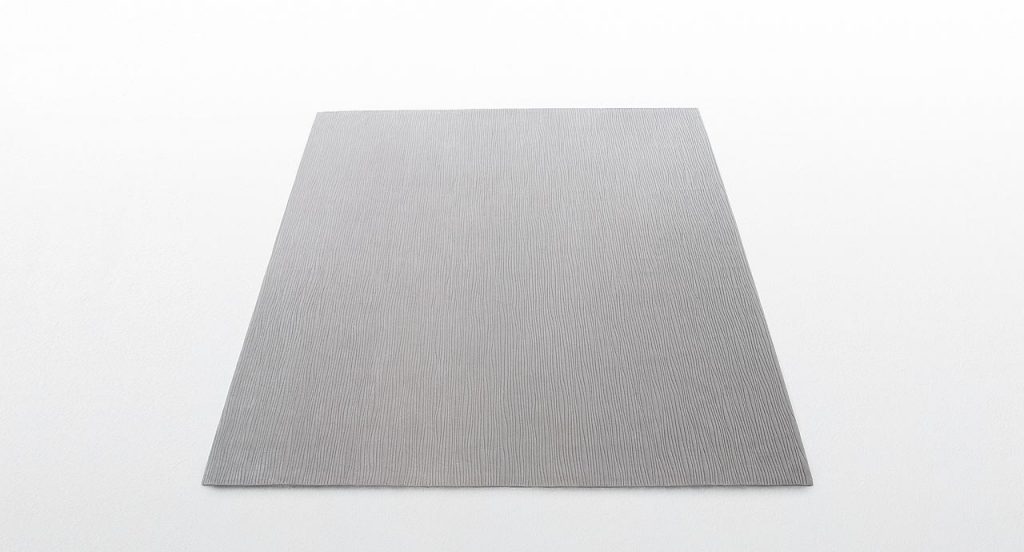 Deep rug made of grey irregular curved lines pattern on a white background.