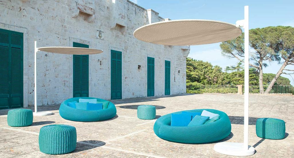 Two Ease round seatings, upholstery in blue in a terrace.