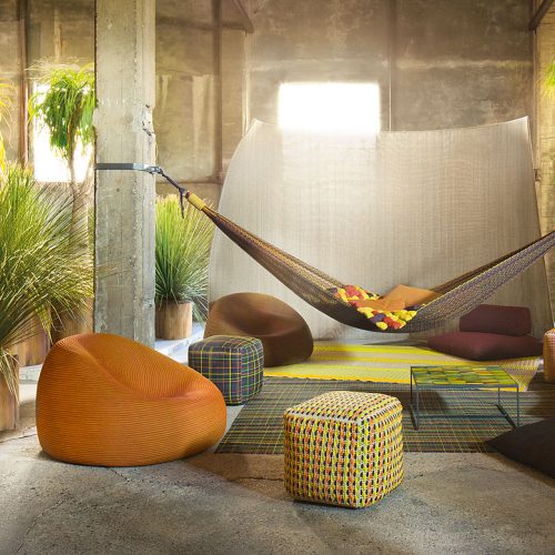 Farniente hammock made of red, yellow, orange, and purple fabric in a living room.