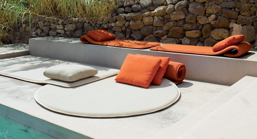 Two Flex seat pads made of three-dimensional orange polyester fabric in a terrace.