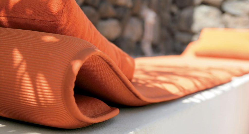 Two Flex seat pads made of three-dimensional orange polyester fabric in a terrace.