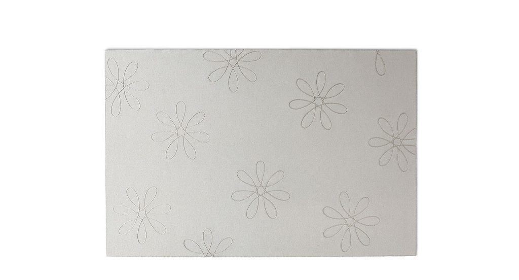 White Flower rug made of felt, the design consists of flowers embroidered in relief on a white background.