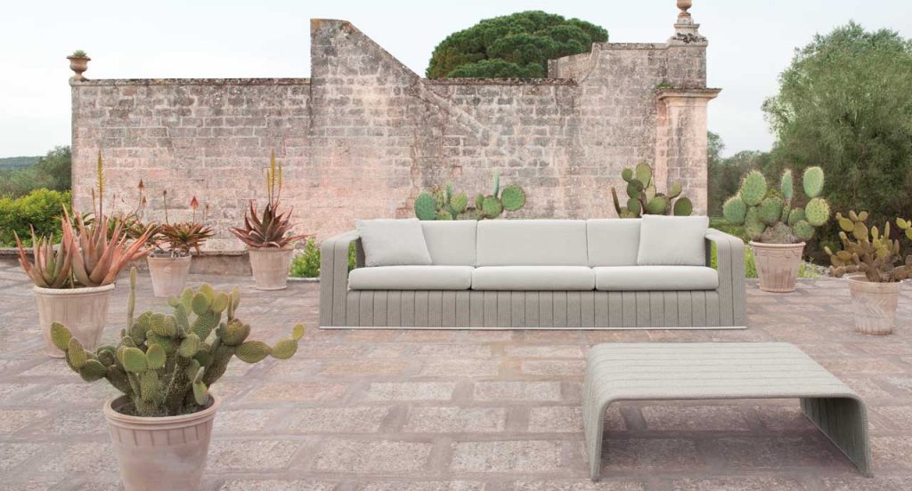 Frame Sectional sofa, upholstery in beige rope braids with four white cushions in a terrace.