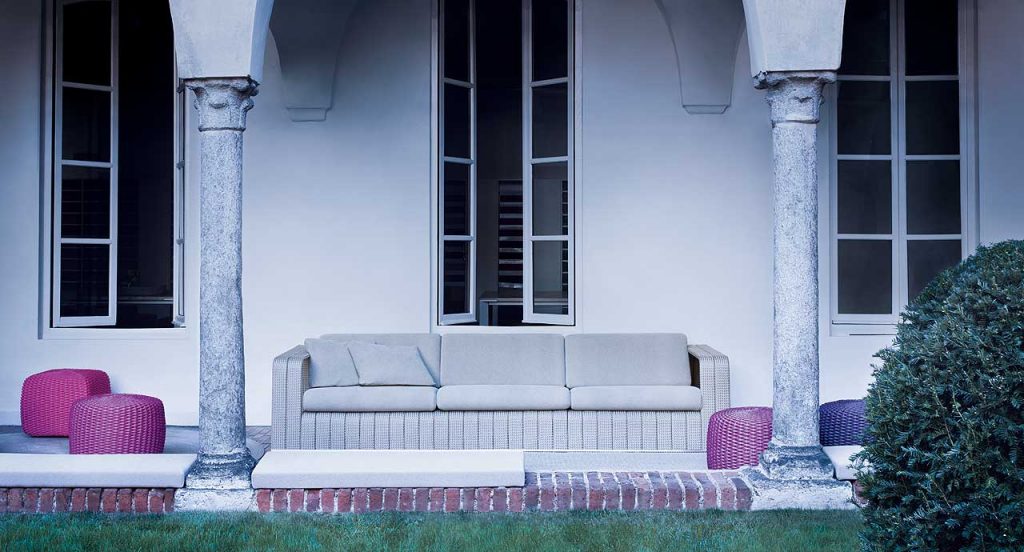 Frame Sectional sofa, upholstery in beige rope braids with four white cushions in a terrace.
