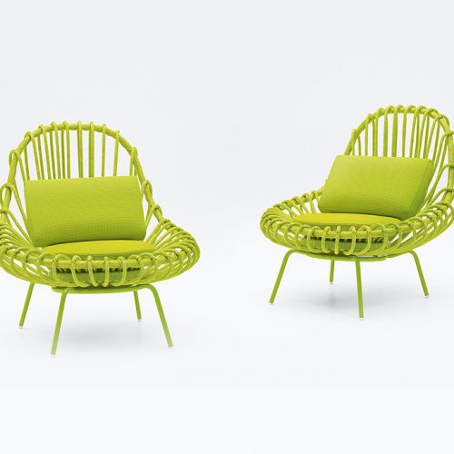 Two green Giunco armchairs, structre and four chairs in steel, two cushions in fabrics on a white background.