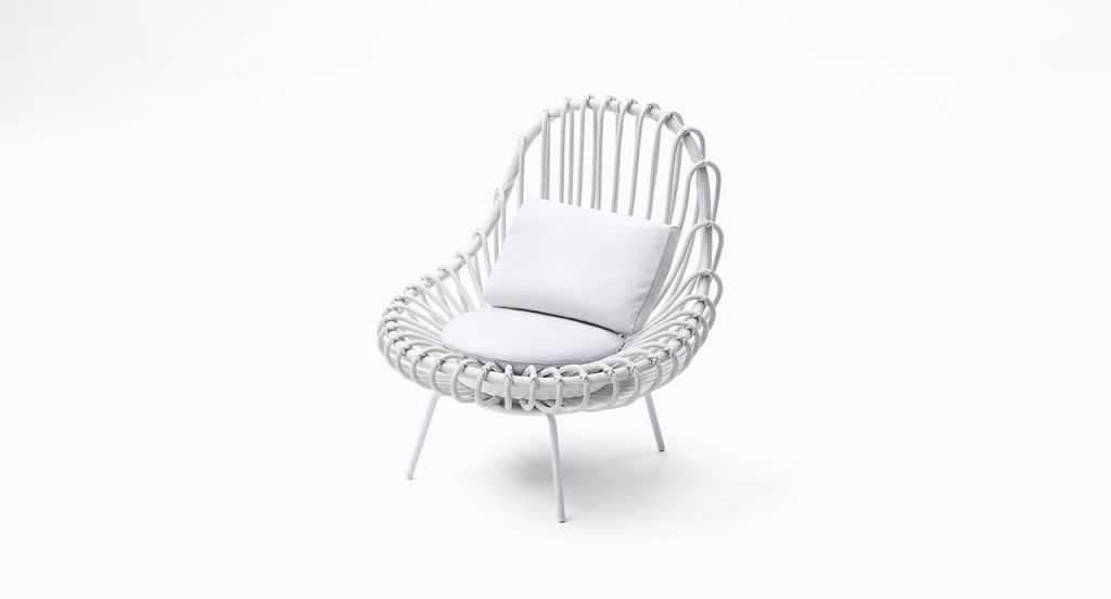 White Giunco armchair, structre and four chairs in steel, two cushions in fabrics on a white background.