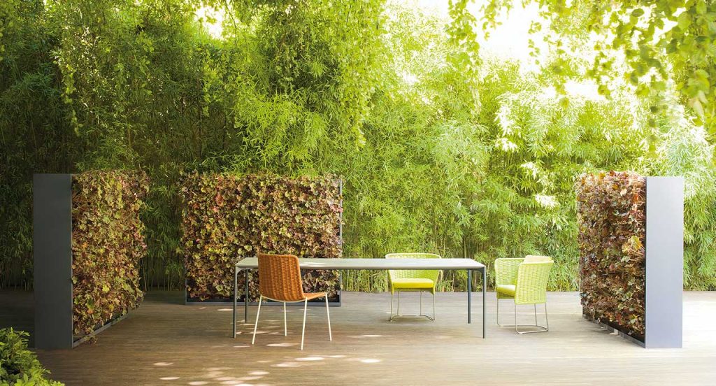 Three Greenery green walls, structure in grey steel, planters in plastic in a garden.