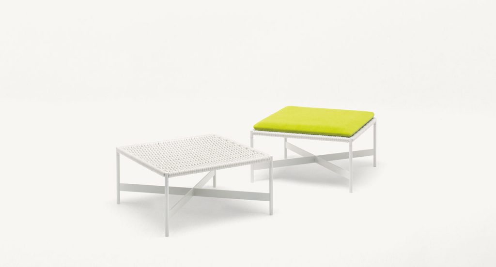 Two white Heron Stools, structure and four legs in steel, upholstery in rope cord, cushion in green on a white background.