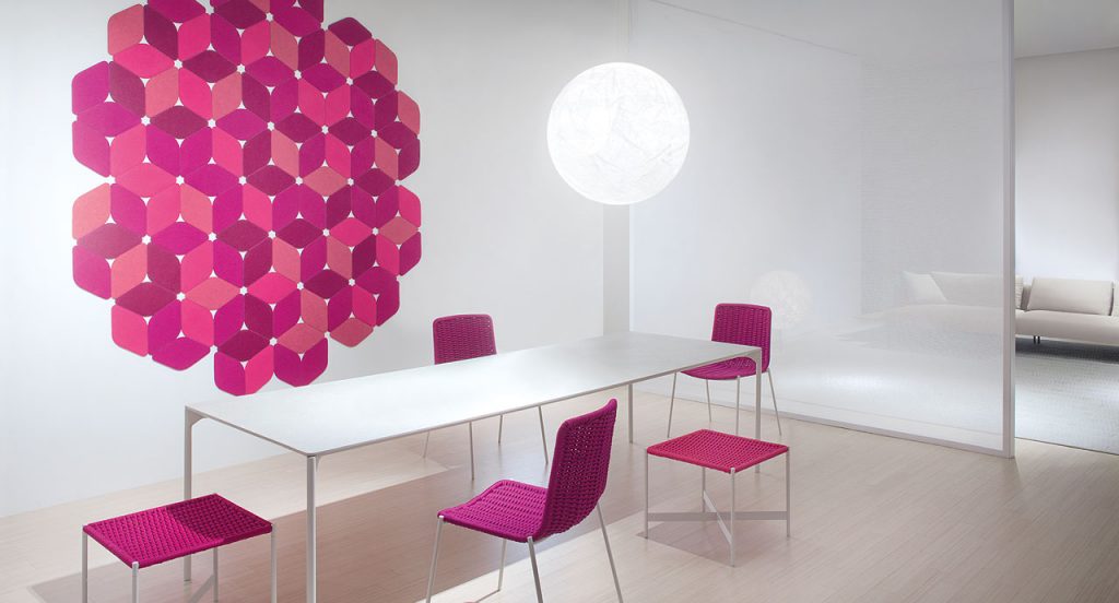 Kaleidoscope rug made of pink and red felt modules in a living room.