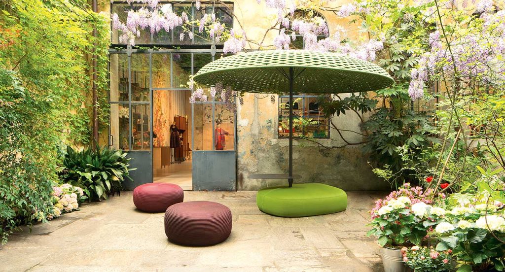 Mogambo parasol, structure in black aluminium and steel, top of green yope yarn in a garden.