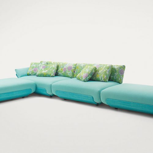 Four blue Oasi, Series of single seatings, two with backrest and one of them with armrest in green and pink garden like patttern on a white background.
