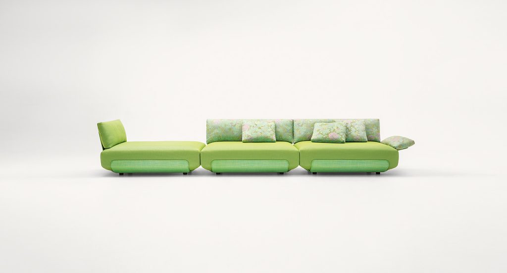 Three green Oasi, Series of single seatings, two with backrest and one with armrest in green and pink garden like patttern on a white background.
