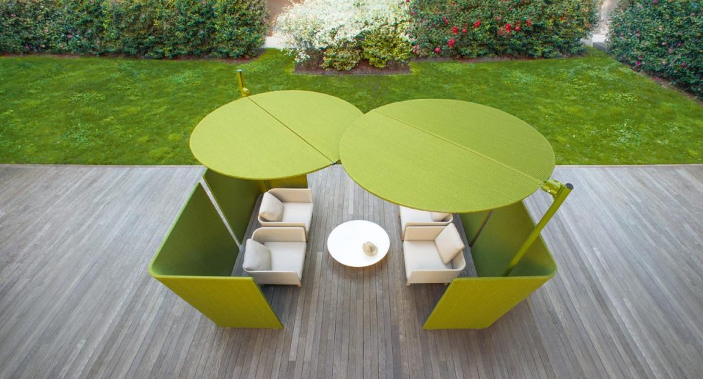 Two green Ombra sunshades top made of two polyester semi circles, leg in aluminum in a terrace.
