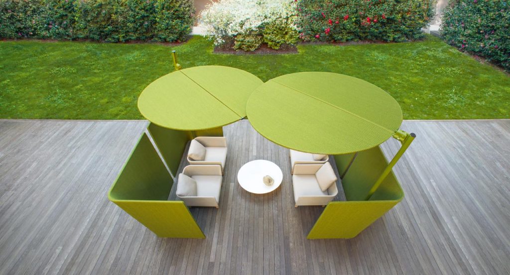 Two green Ombra sunshades top made of two polyester semi circles, leg in aluminum in a terrace.