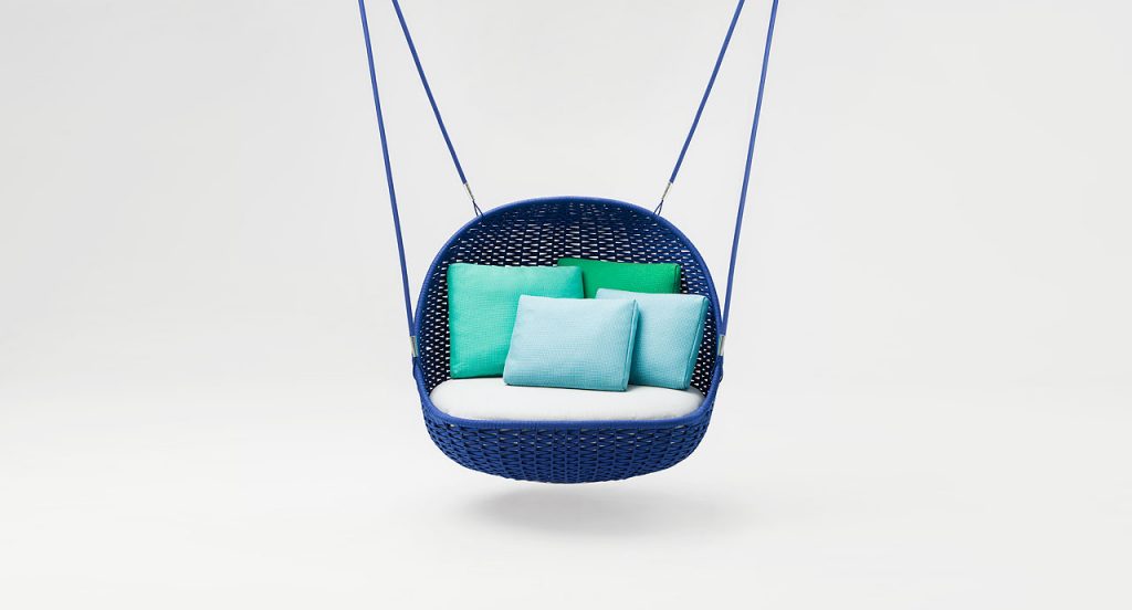 Blue suspended Orbitry Swing seat, structural weave in flad braids with white cushions on a white background.