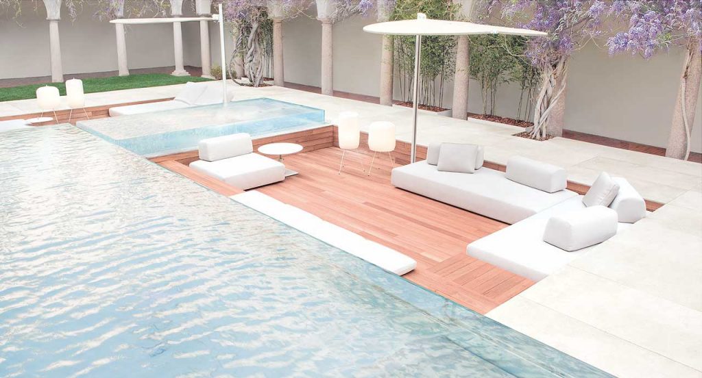 Three Orlando Outdoor Sectionals with backrest, upholstered in white fabric next to a pool.