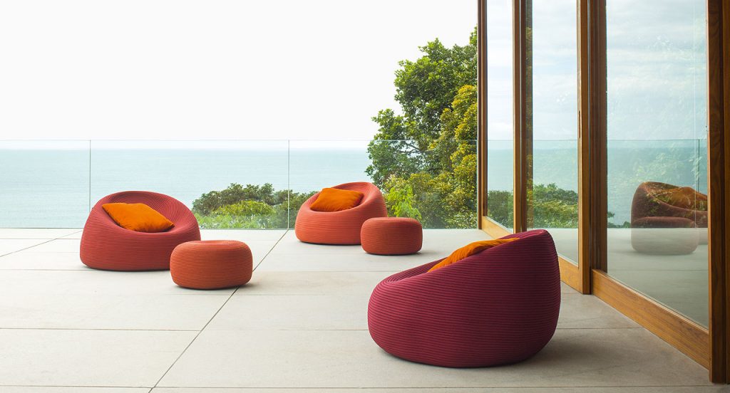 Three Otto Armchairs, upholstery in red rope cord in a terrace.