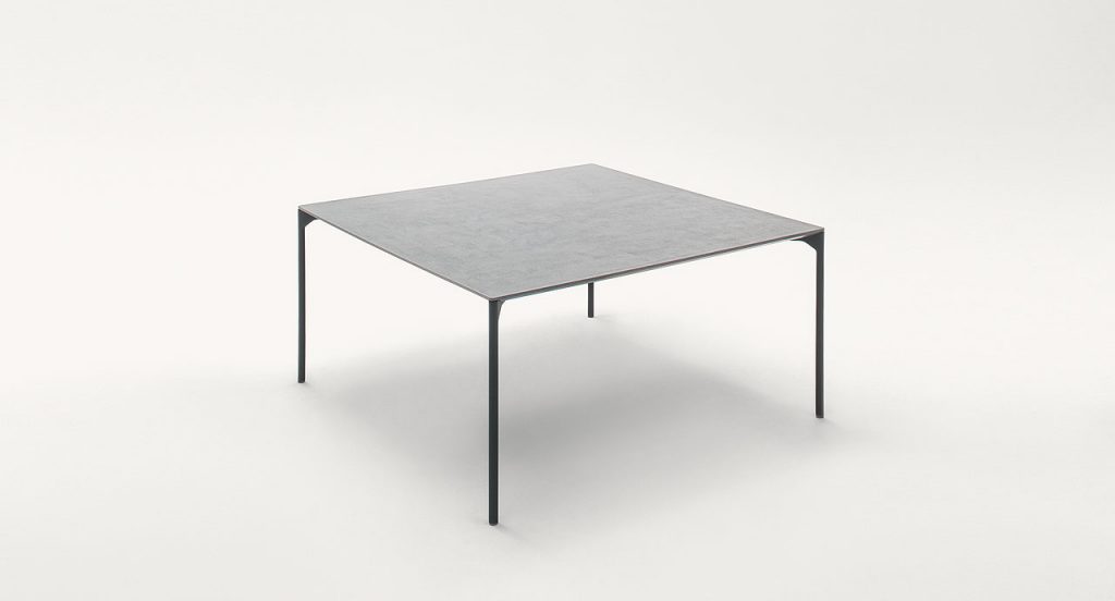 Square Plano Outdoor Dining Table, structure in black steel, shelves in white concrete on a white background.