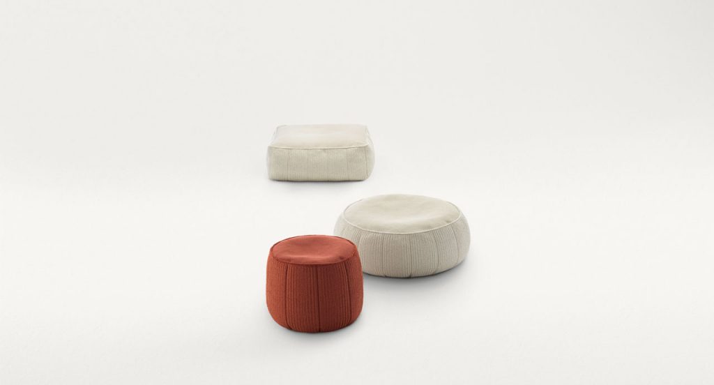 Three Play poufs, two in white and one in red fabric upholstery. Two in round and one in square shape on a white background.