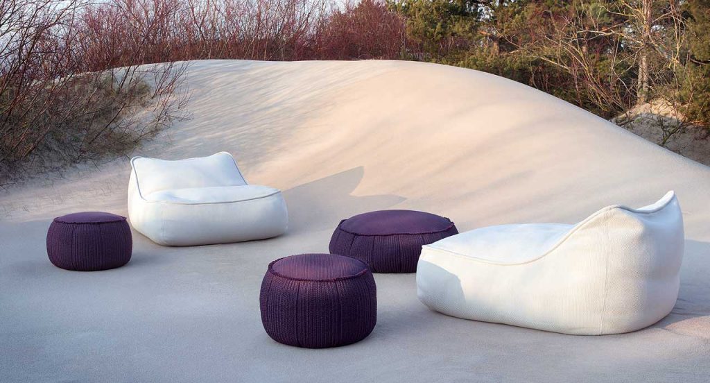 Three Play poufs in purple fabric upholstery, round shape in a garden.