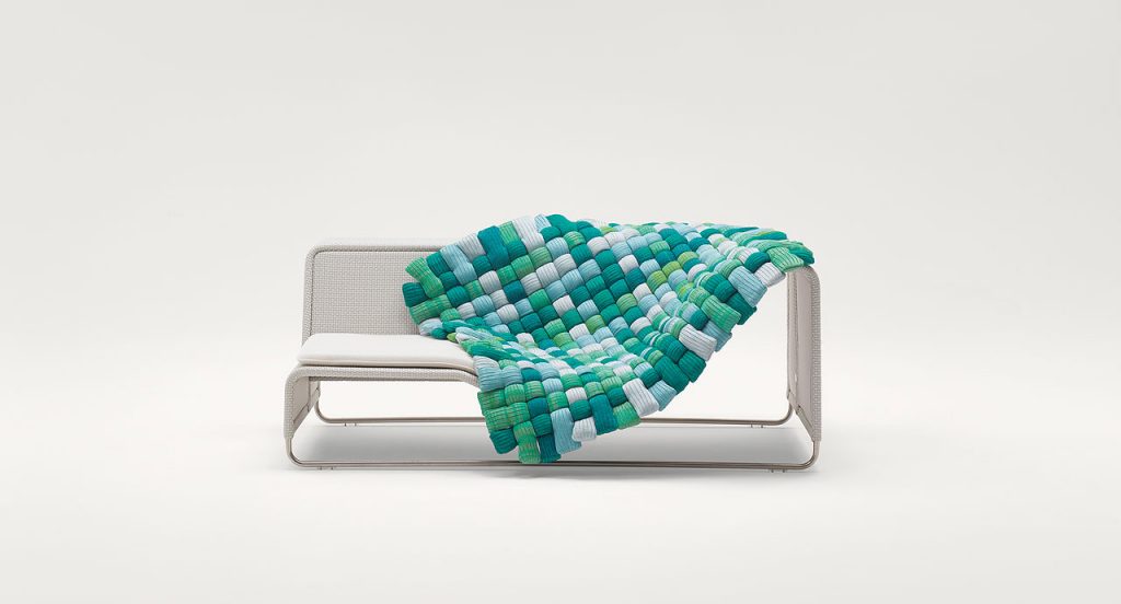Plump pad Chain Outodoor tubular knit, padding in blue, green and white polyester fiber on a sofa on a white background.