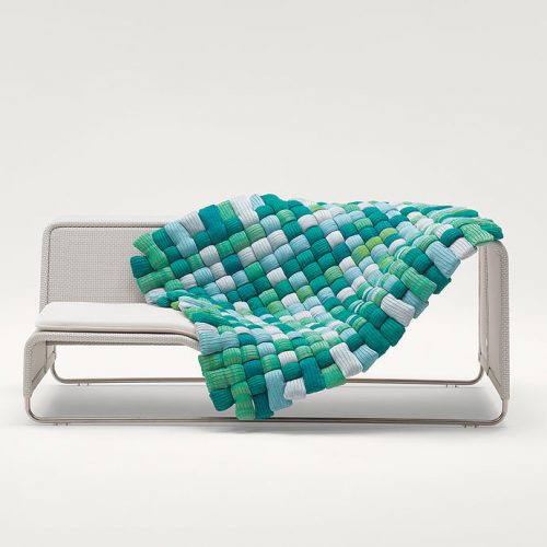 Plump pad Chain Outodoor tubular knit, padding in blue, green and white polyester fiber on a sofa on a white background.