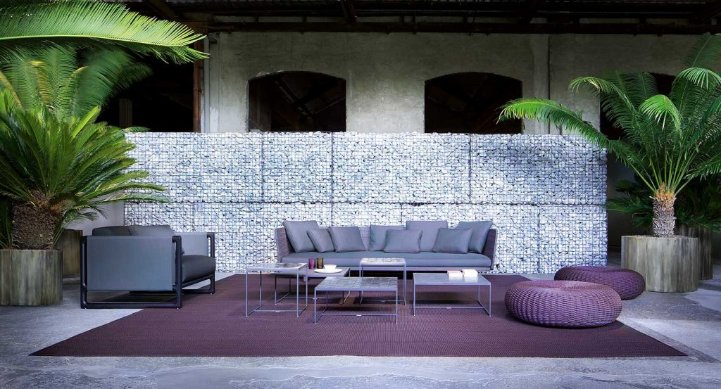 Portofino Outdoor Armchair, structure in black steel, cushions in blue polyester in a living room.
