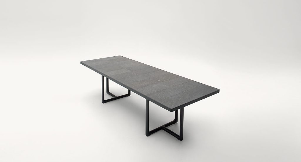 Large Portofino Outdoor Dining Table, two legs in dark heartwood, top in natural lava stone on a white background.