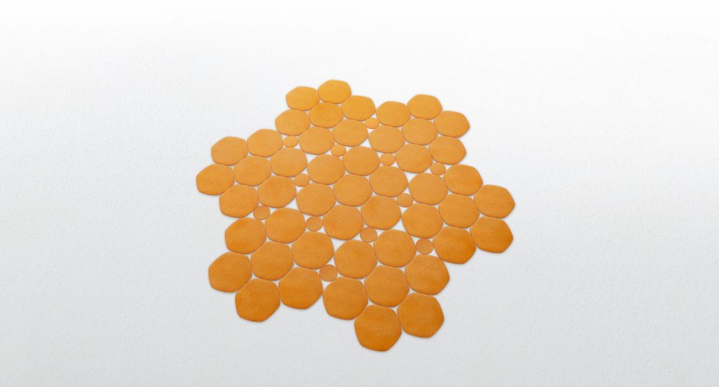 Prisma rug made by hexagonal, irregular forms in orange felt on a white background.