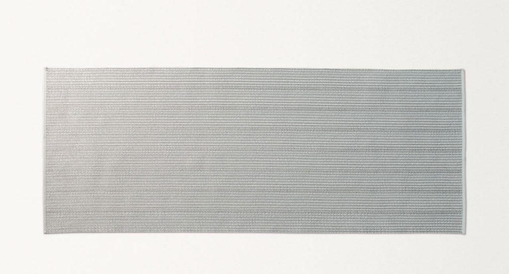 Ray rug made with grey wide braids on a white background.