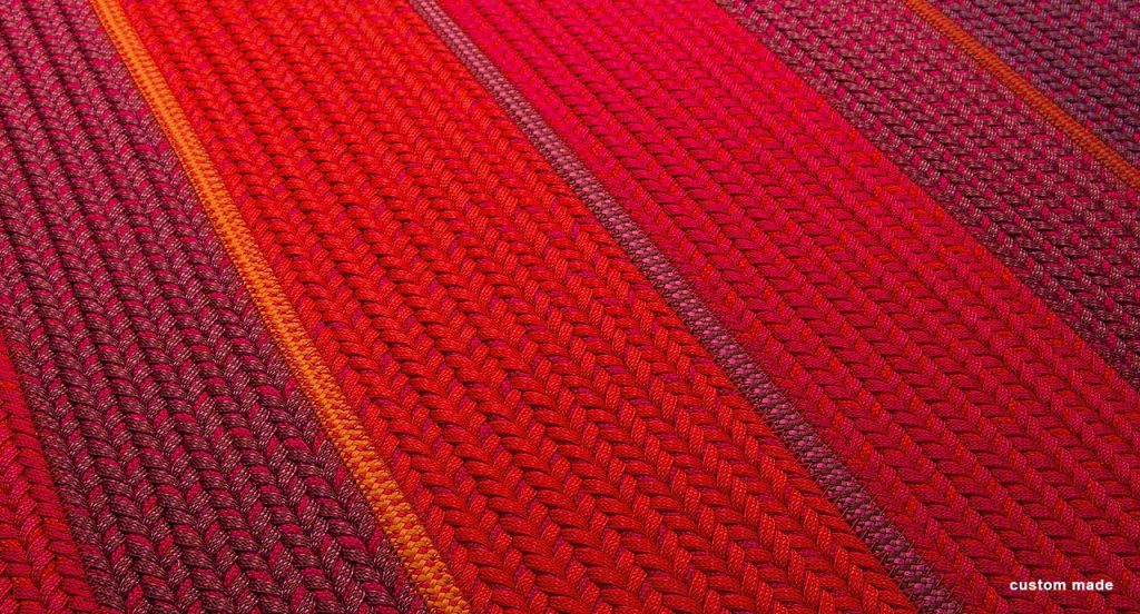 Ray rug made with red wide braids.