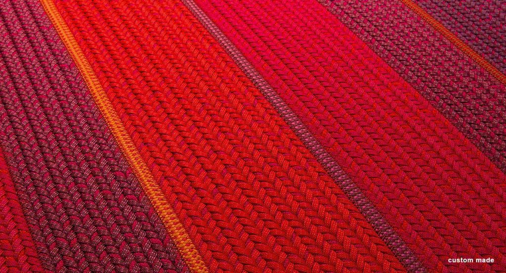 Ray rug made with red wide braids.