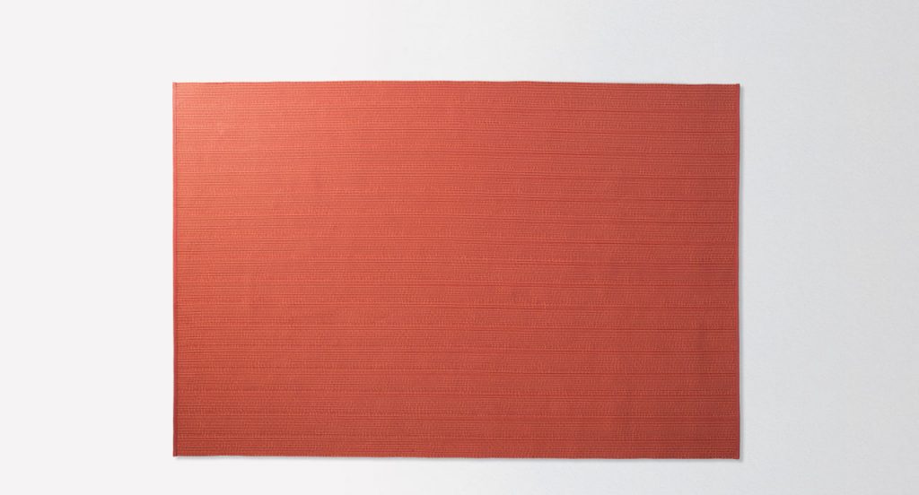Ray rug made with red wide braids on a white background.