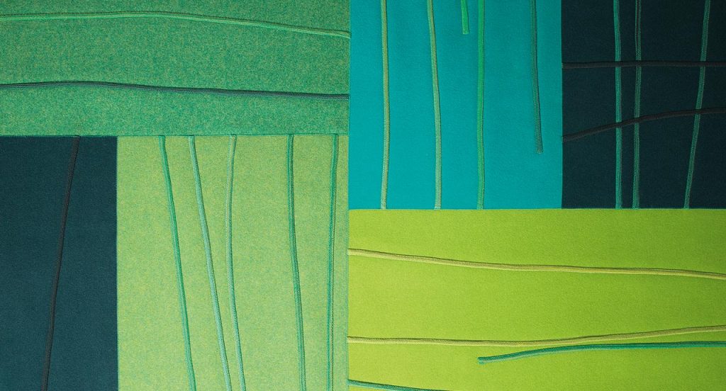 Blue and green Rilievo rug in wool cords and lines like pattern.