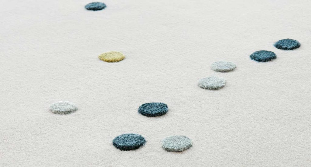White Rosae rug, round reised pattern in grey, blue and yellow wool.