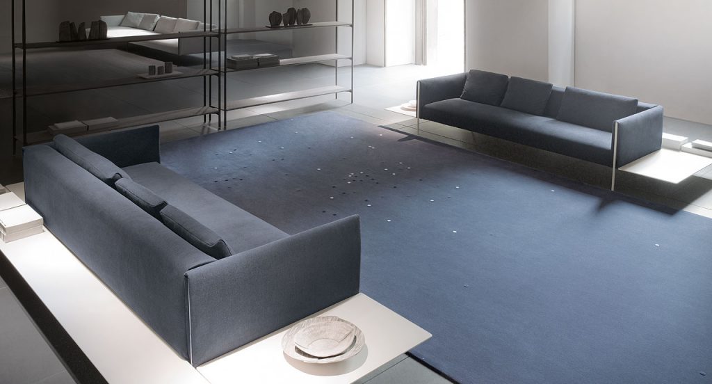 Blue Rosae rug, round reised pattern in grey, blue and yellow wool in a living room.