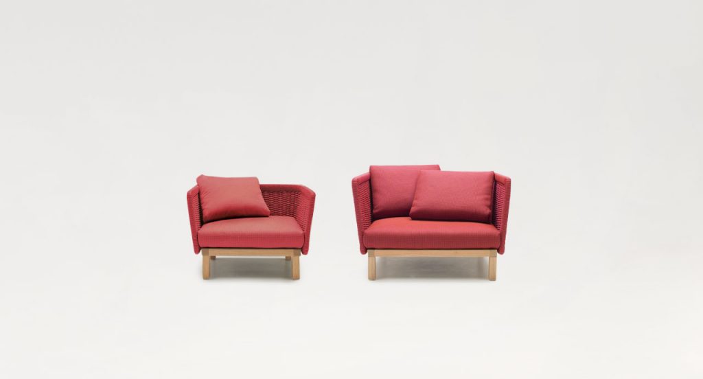Two red Sabi Armchairs, base and two legs made of natural wood, backrest in woven rope cord and cushion in fabric on a white background.