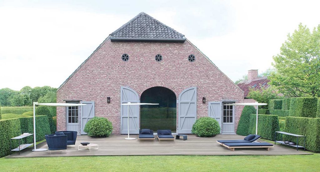 Two Sabi Sun Beds, structure in natural wood, seat pad in blue polyester in a terrace