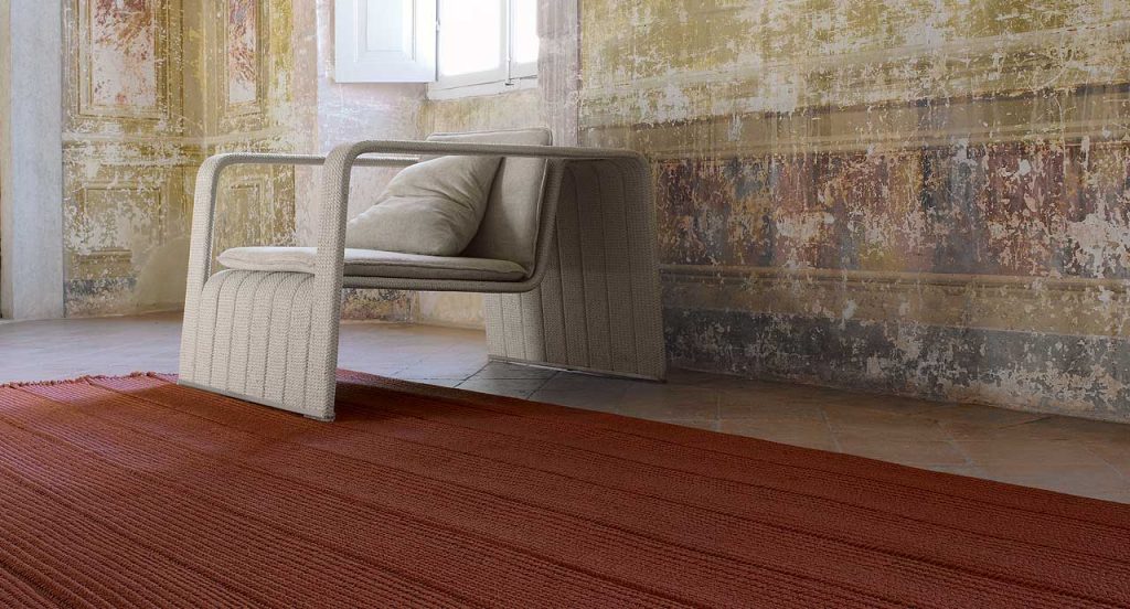 Sahara rug made of brown Aquatech braids in a yellow, red and grey lines like pattern room.