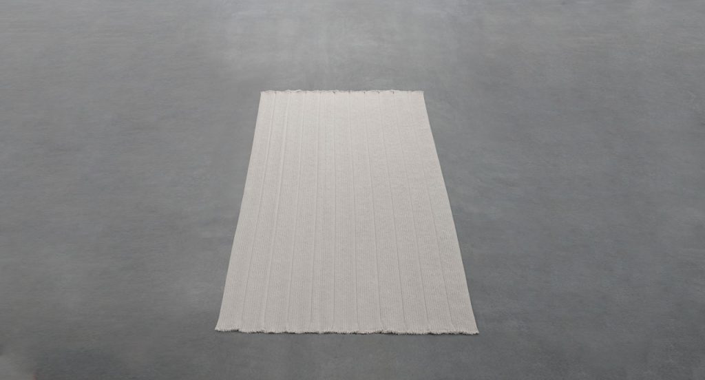 Sahara rug made of white Aquatech braids on a grey background.