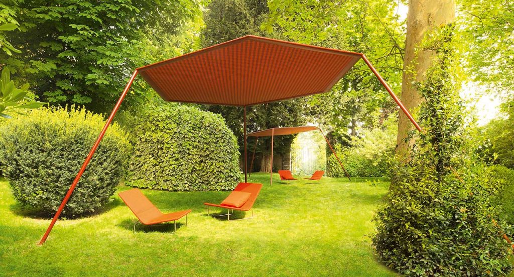 Four orange Sand lounge chair with backrest, structure in steel , upholstery in rope fabric, cushion in polyester in a garden.